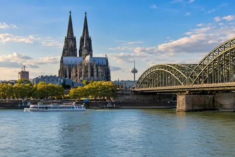 Illustrative Stadtansicht von Köln mit Dom, Hohenzollernbrücke und Rhein.