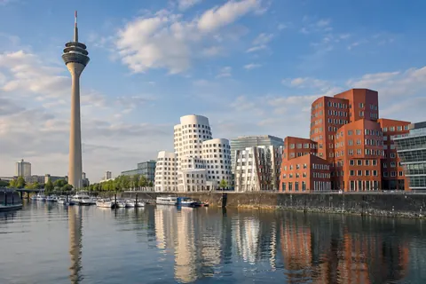 Illustrative Stadtansicht des Düsseldorfer Medienhafens mit Rheinturm und Gehry-Bauten.