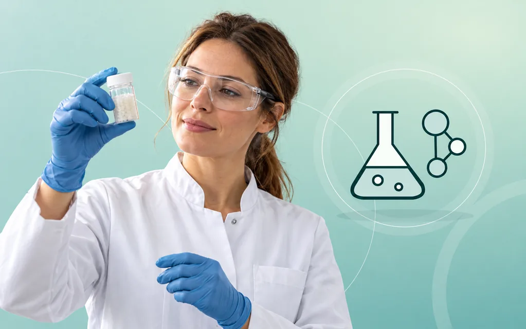 Chemiefachkraft mit Schutzbrille und Handschuhen untersucht eine verschlossene Materialprobe.